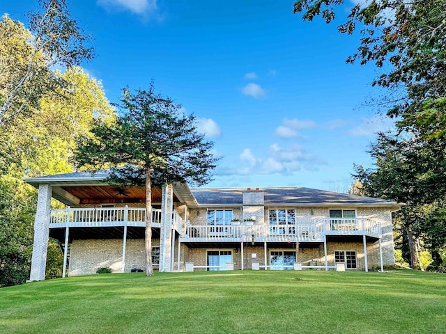 rear view of house with a yard and a deck