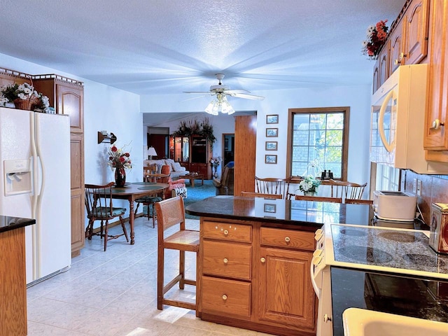 63574 Lohmann Ln, Eastman, WI 52626 - kitchen featuring white appliances, a textured ceiling, dark countertops, a peninsula, and ceiling fan