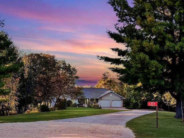 view of front of home with a garage and a yard