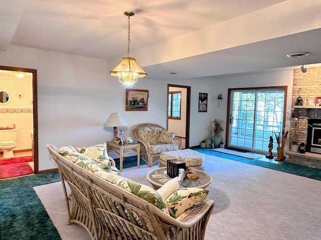 63574 Lohmann Ln, Eastman, WI 52626 - carpeted living room with a brick fireplace, a chandelier, and baseboards