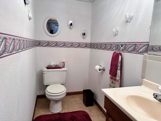 63574 Lohmann Ln, Eastman, WI 52626 - half bathroom featuring toilet, tile patterned flooring, a textured wall, vanity, and baseboards