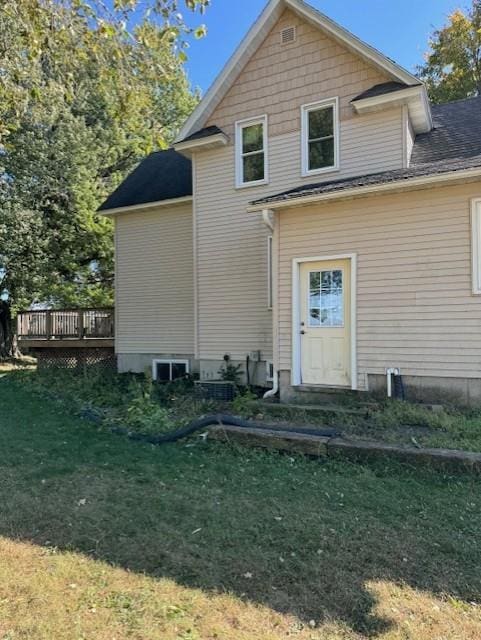 rear view of property with a deck and a yard