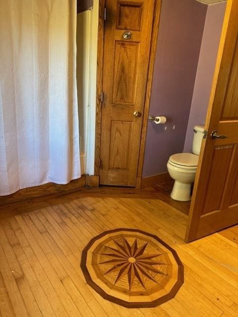 bathroom with wood-type flooring and toilet