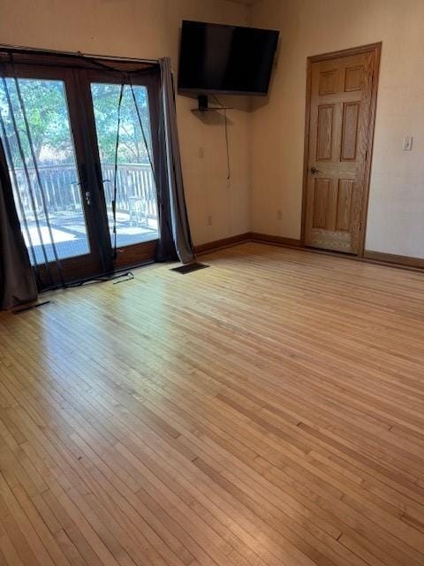 unfurnished room featuring french doors and light wood-type flooring