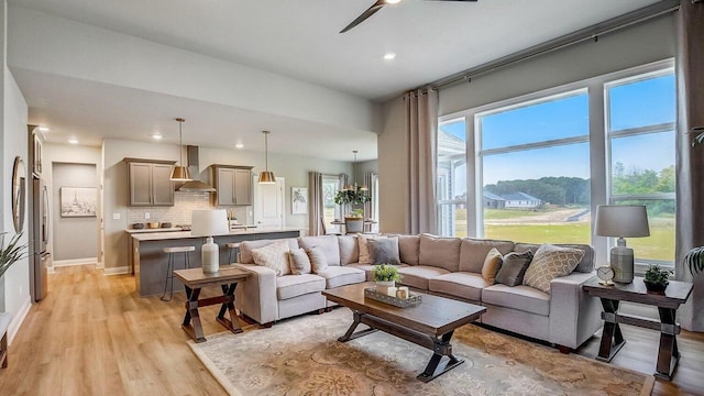 living room with light wood-type flooring and ceiling fan