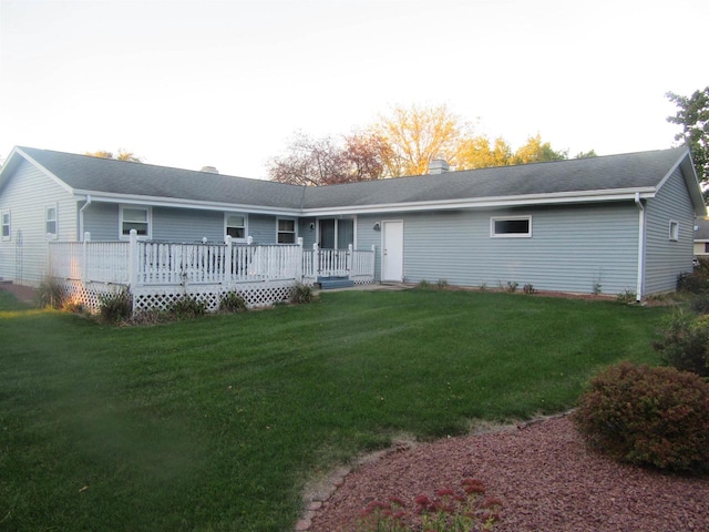 rear view of house featuring a lawn and a wooden deck