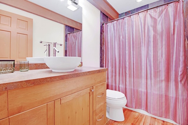 full bathroom with shower / bath combination with curtain, vanity, hardwood / wood-style floors, and toilet