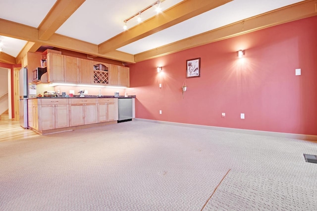 interior space featuring light brown cabinetry, light colored carpet, beam ceiling, and rail lighting