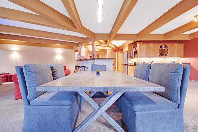 carpeted dining area featuring beamed ceiling