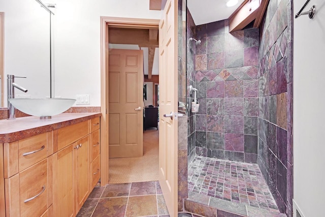 bathroom with vanity and tiled shower