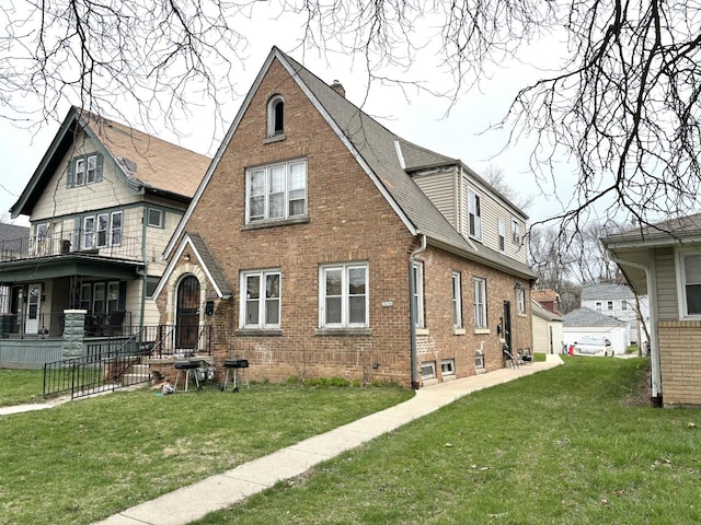 back of property with a garage, a balcony, and a lawn