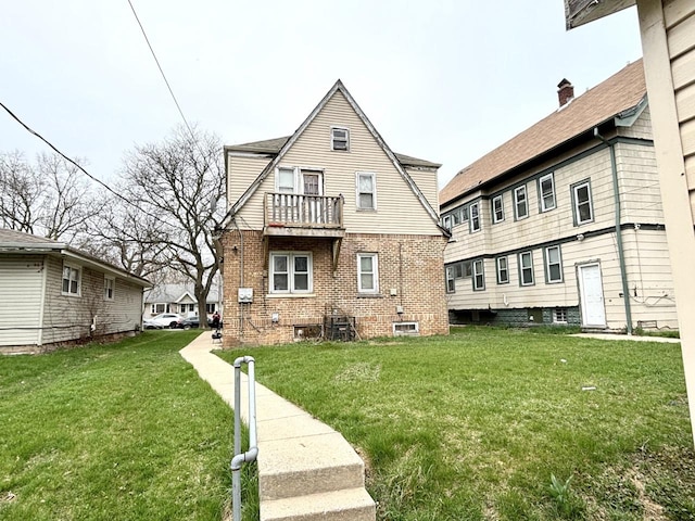 back of property with a balcony and a lawn