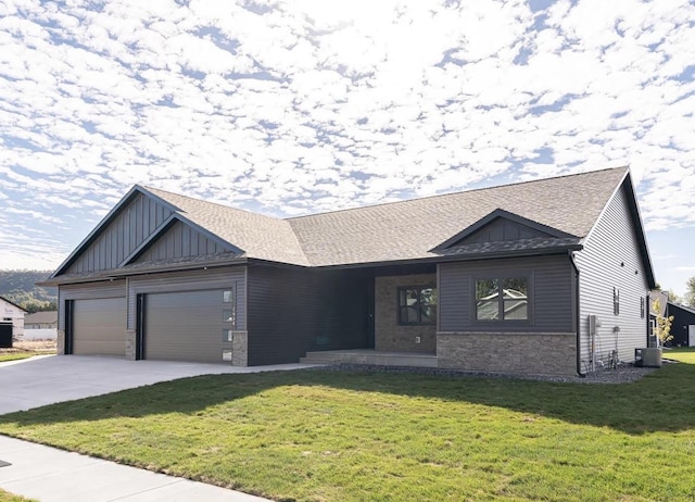 view of front facade featuring a front yard, a garage, and central AC