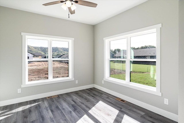 unfurnished room with ceiling fan and dark wood-type flooring