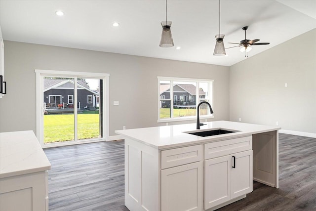 kitchen with white cabinets, pendant lighting, sink, a center island with sink, and dark hardwood / wood-style floors