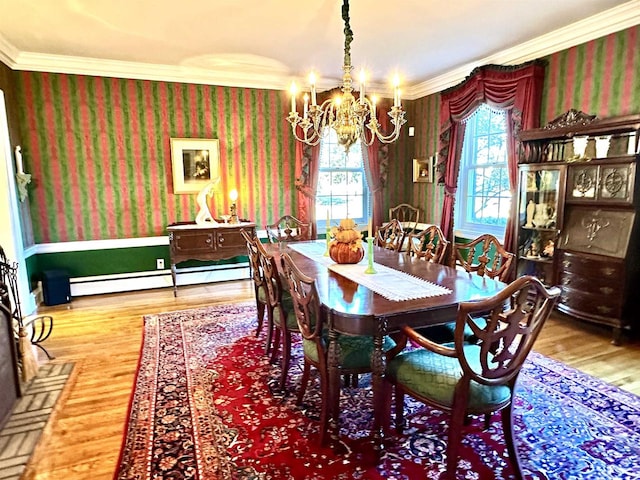 dining room featuring baseboard heating, hardwood / wood-style floors, plenty of natural light, and ornamental molding