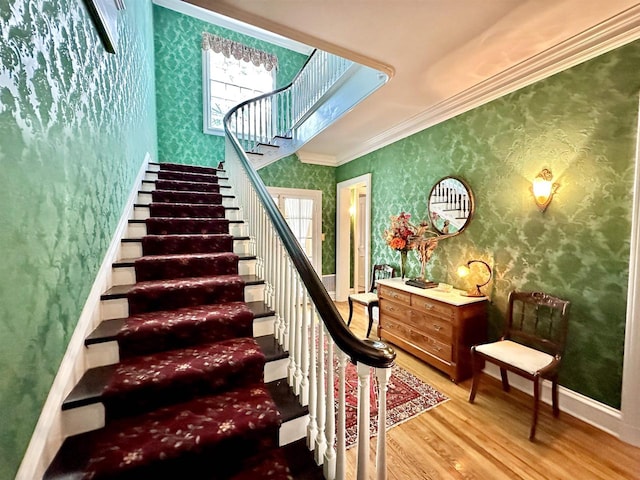 staircase featuring hardwood / wood-style floors and crown molding