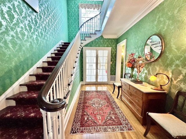 stairway featuring crown molding, hardwood / wood-style floors, and french doors