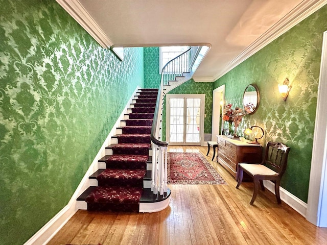 stairs featuring wood-type flooring and crown molding