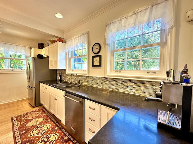 kitchen featuring decorative backsplash, sink, white cabinetry, and stainless steel appliances