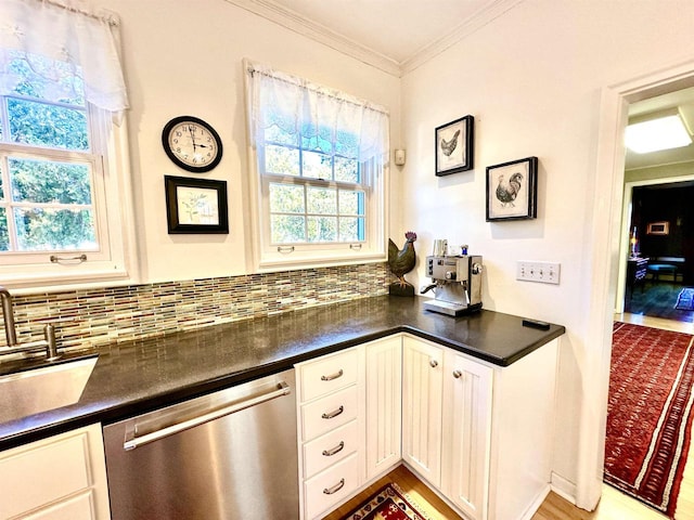 kitchen with a healthy amount of sunlight, crown molding, stainless steel dishwasher, and light hardwood / wood-style floors