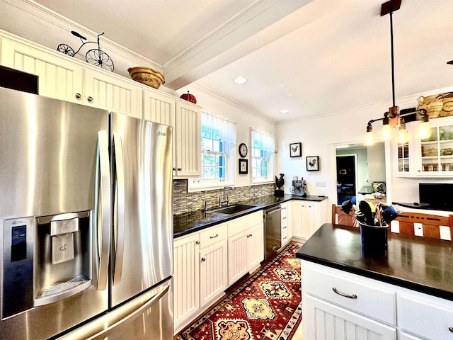 kitchen with decorative backsplash, appliances with stainless steel finishes, ornamental molding, sink, and hanging light fixtures