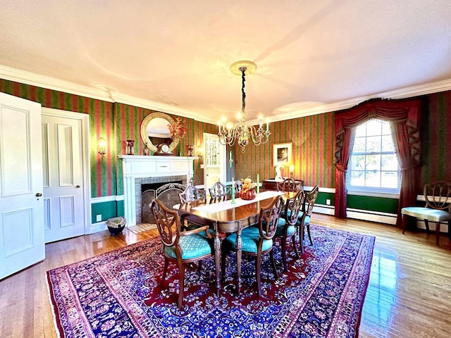 dining room featuring a brick fireplace, baseboard heating, a notable chandelier, crown molding, and wood-type flooring