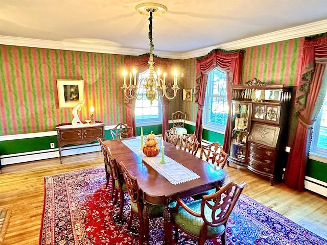 dining area with hardwood / wood-style floors, a chandelier, and ornamental molding