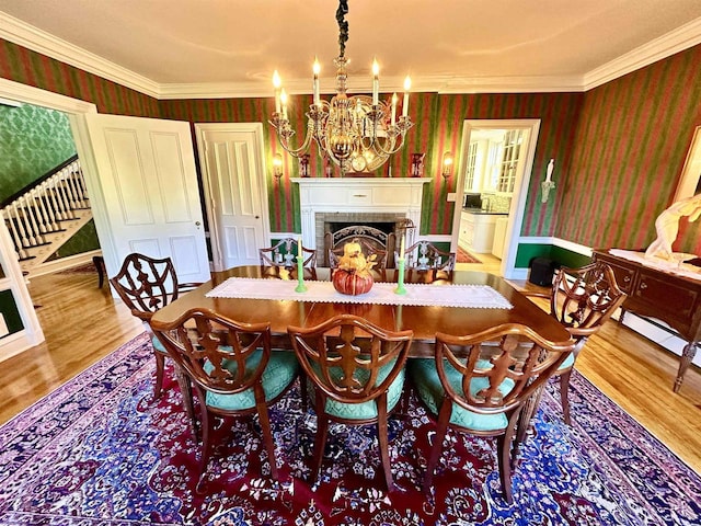 dining room featuring an inviting chandelier, ornamental molding, and hardwood / wood-style flooring