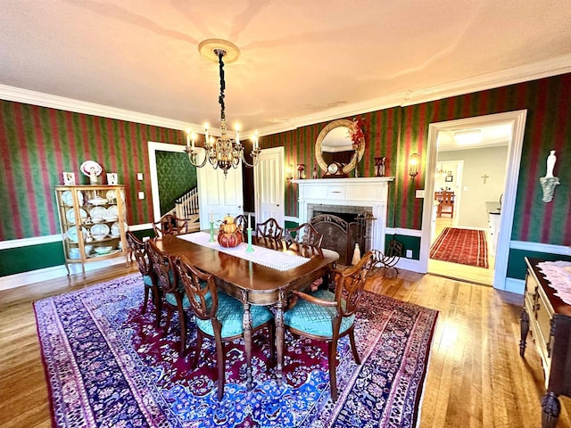 dining room featuring light wood-type flooring, ornamental molding, and a chandelier