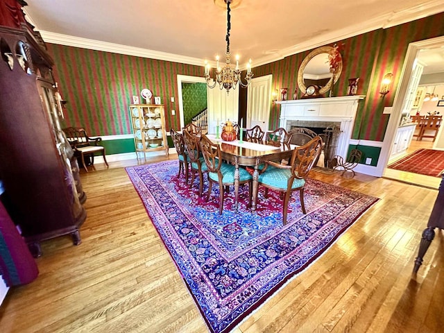 dining room featuring an inviting chandelier, light hardwood / wood-style flooring, and crown molding