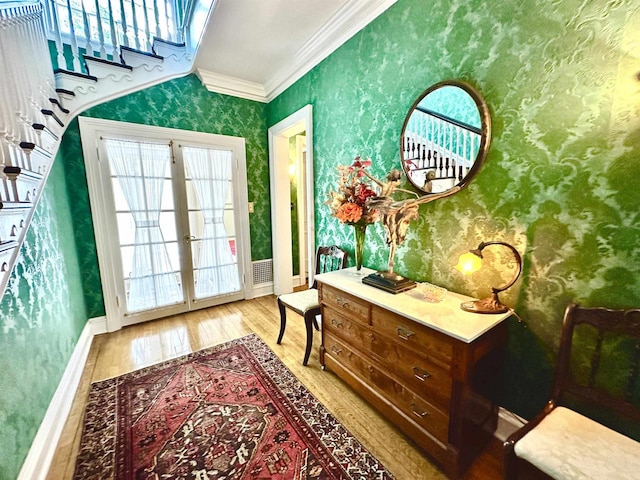 entryway featuring french doors, light wood-type flooring, and ornamental molding