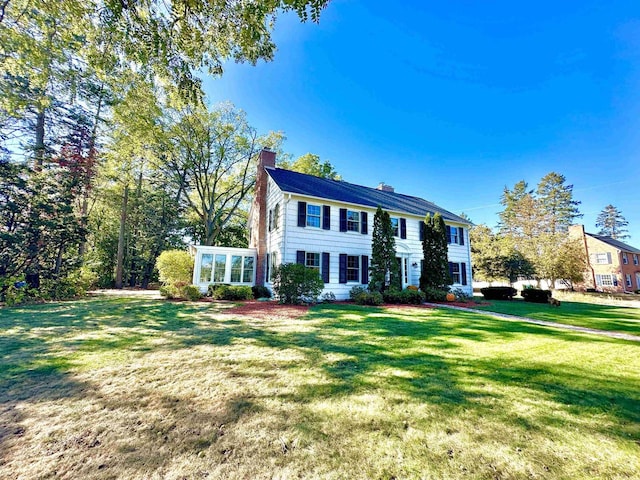 colonial-style house featuring a front lawn