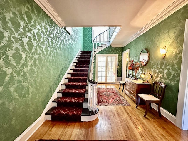 staircase with hardwood / wood-style flooring and ornamental molding