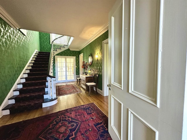 entryway featuring ornamental molding and light hardwood / wood-style flooring