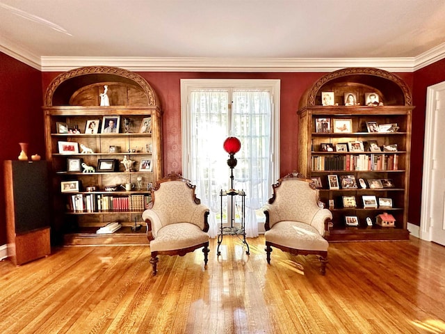 living area featuring hardwood / wood-style flooring and crown molding