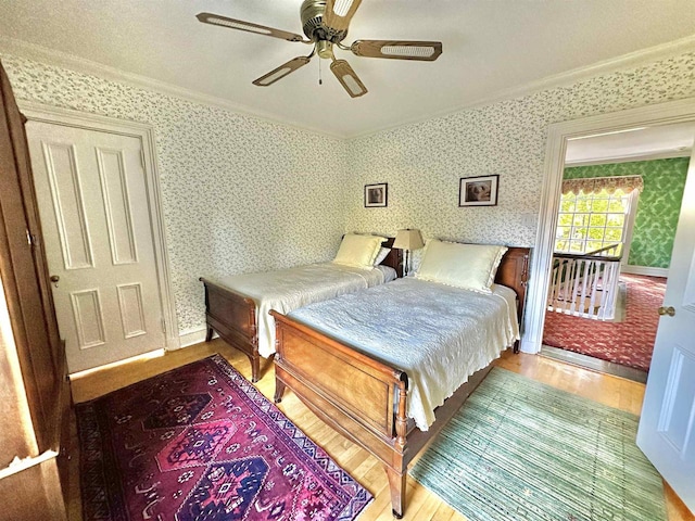 bedroom featuring hardwood / wood-style floors, ceiling fan, and crown molding