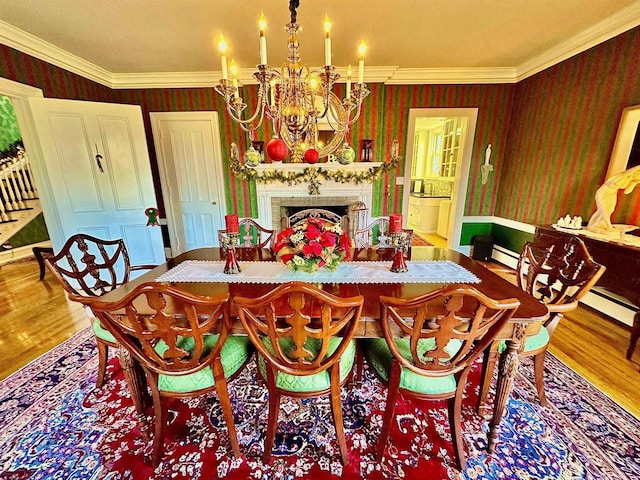 dining room with hardwood / wood-style flooring, a notable chandelier, crown molding, and a brick fireplace