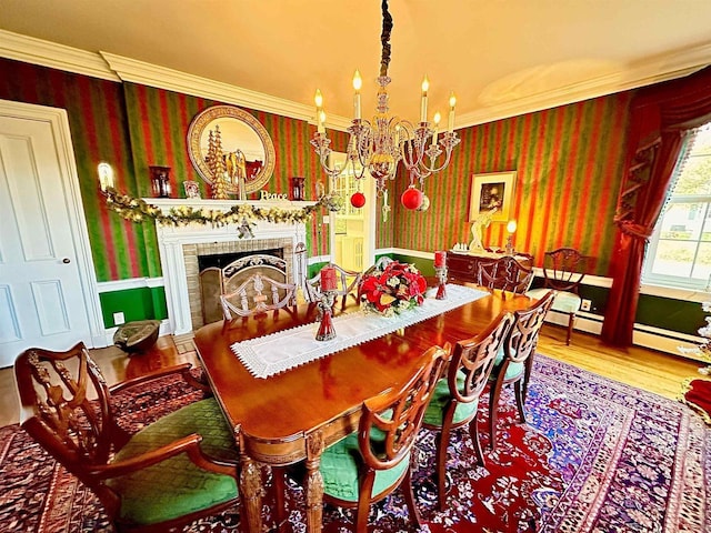 dining area featuring hardwood / wood-style floors, ornamental molding, a fireplace, and a chandelier