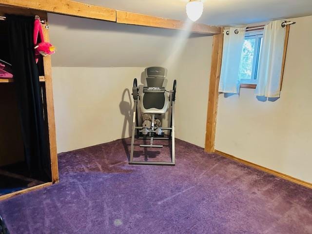 workout room featuring lofted ceiling and dark carpet