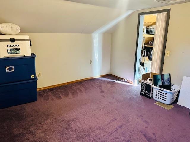 bonus room with dark carpet and lofted ceiling