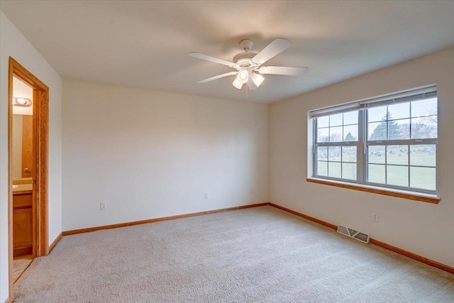 empty room featuring light colored carpet and ceiling fan