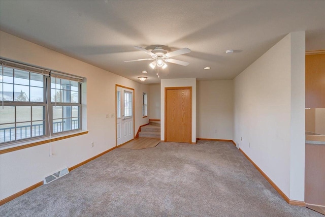 carpeted spare room featuring ceiling fan