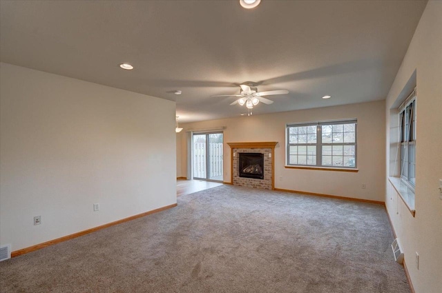 unfurnished living room with a brick fireplace, ceiling fan, and light carpet