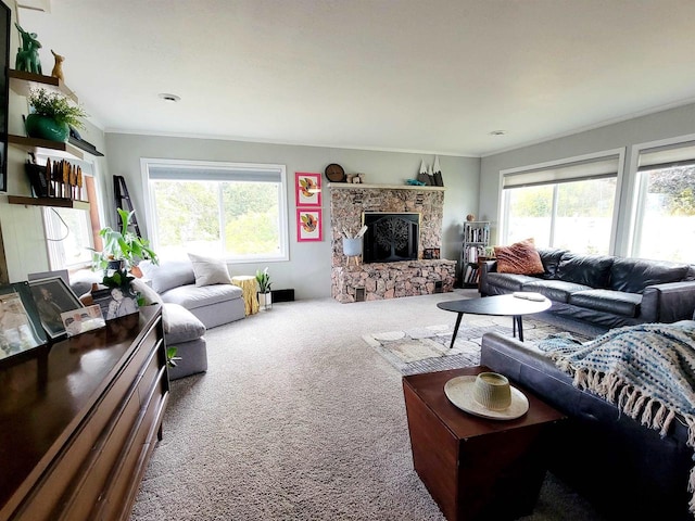 living room featuring a stone fireplace, crown molding, and carpet floors