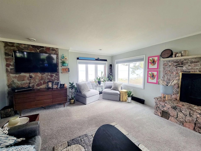 living room with a stone fireplace, crown molding, and carpet flooring