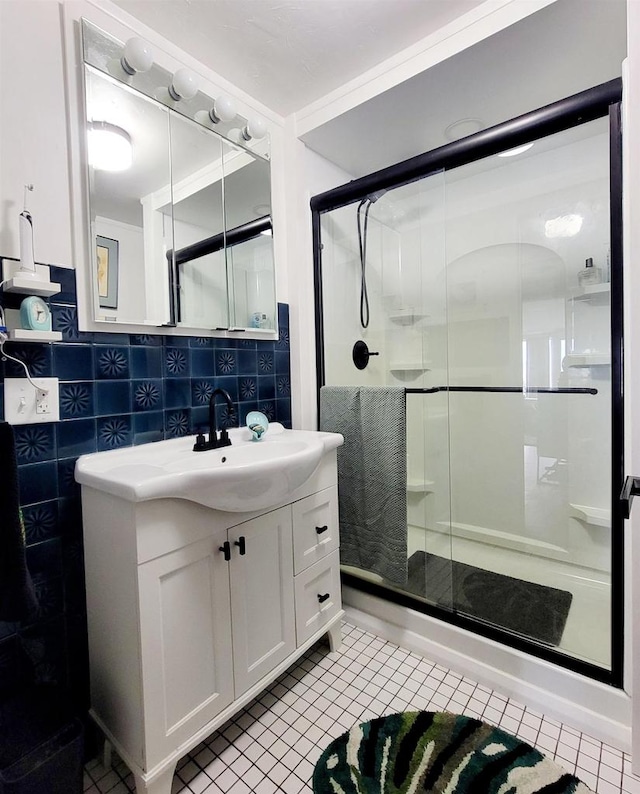 bathroom with vanity, tile walls, a shower with shower door, and tile patterned flooring