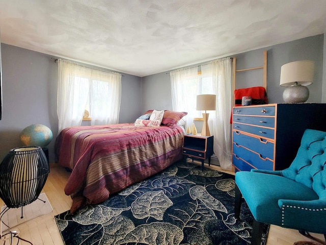 bedroom with hardwood / wood-style floors and multiple windows