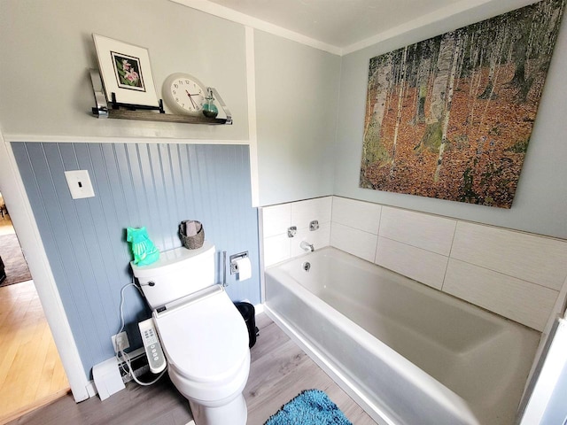 bathroom with a bath, toilet, and hardwood / wood-style floors