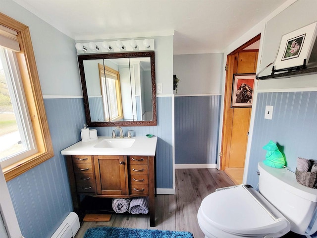 bathroom featuring baseboard heating, vanity, hardwood / wood-style floors, and toilet